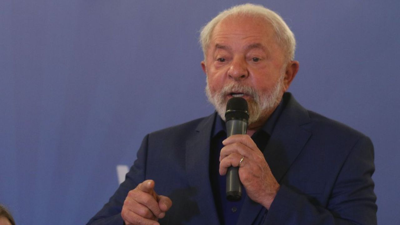 Lula falando em microfone, de paletó azul marinho