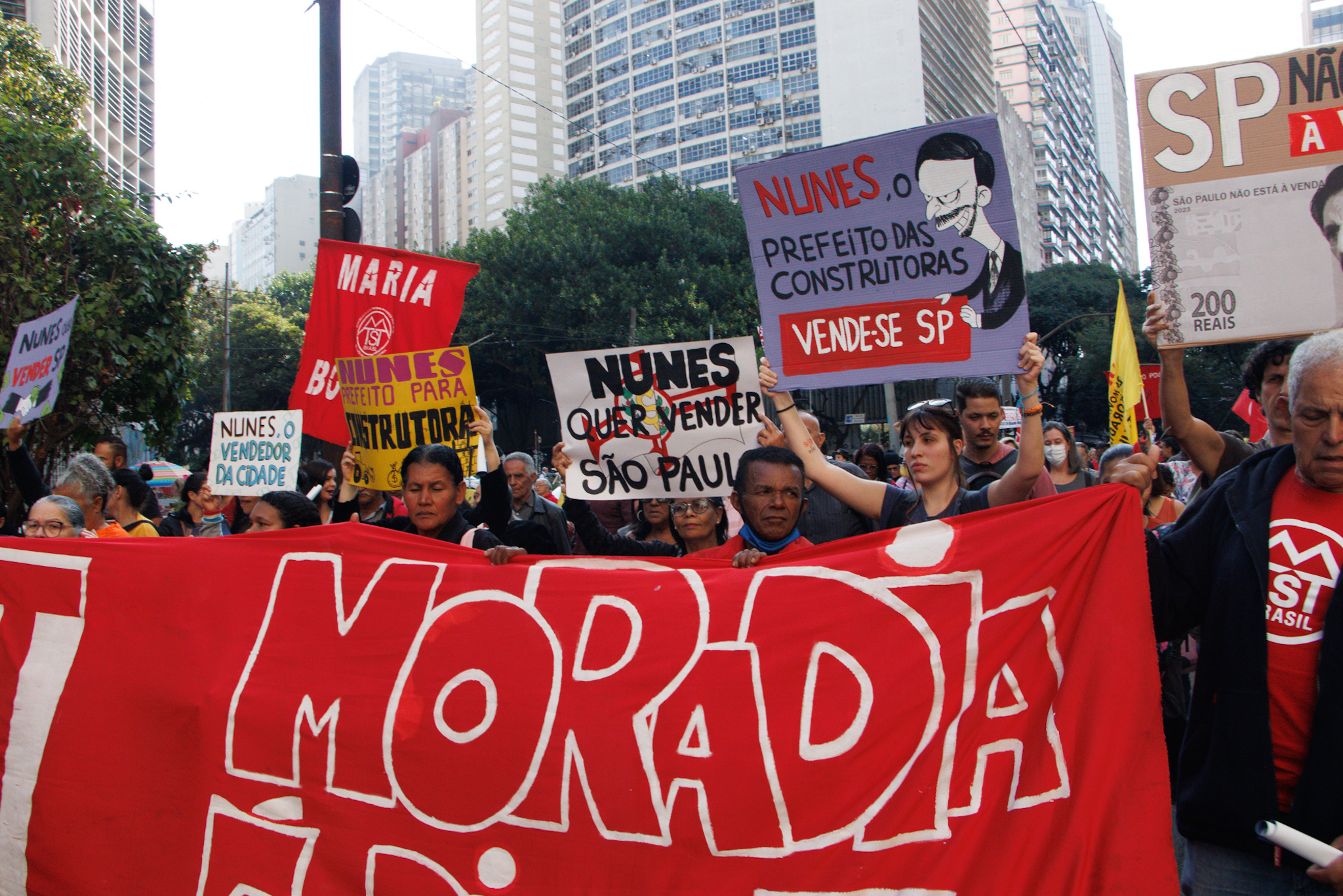 Manifestantes com cartazes e faixa em protesto do MTST