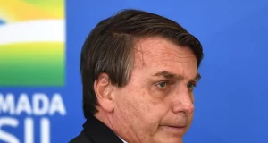 Jair Bolsonaro de perfil, com expressão de insatisfação