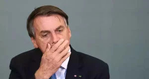 Jair Bolsonaro com expressão de cansaço e mão no rosto