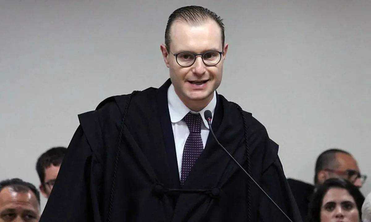 Cristiano Zanin falando em microfone, de óculos
