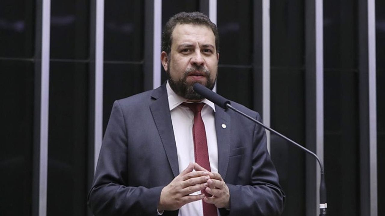 Guilherme Boulos falando em microfone e gesticulando