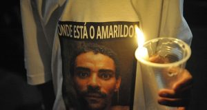 Pessoa segurando copo com vela e vestindo camisa sobre Amarildo
