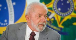 Lula de perfil com expressão séria e terno cinza