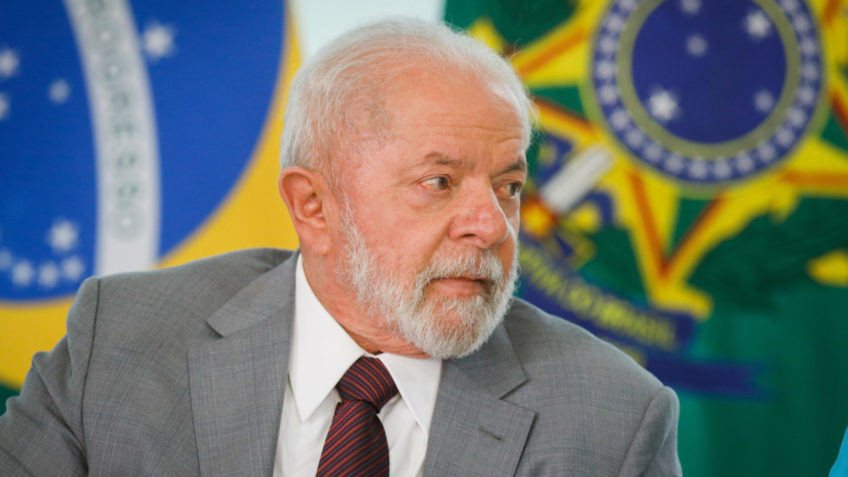 Lula de perfil com expressão séria e terno cinza