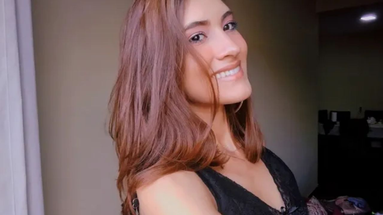 Dalliene de Cassia Brito Pereira sorrindo, de cabelo solto e blusa preta