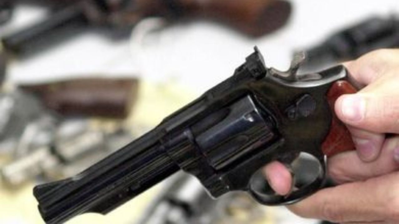 Mão segurando arma de fogo