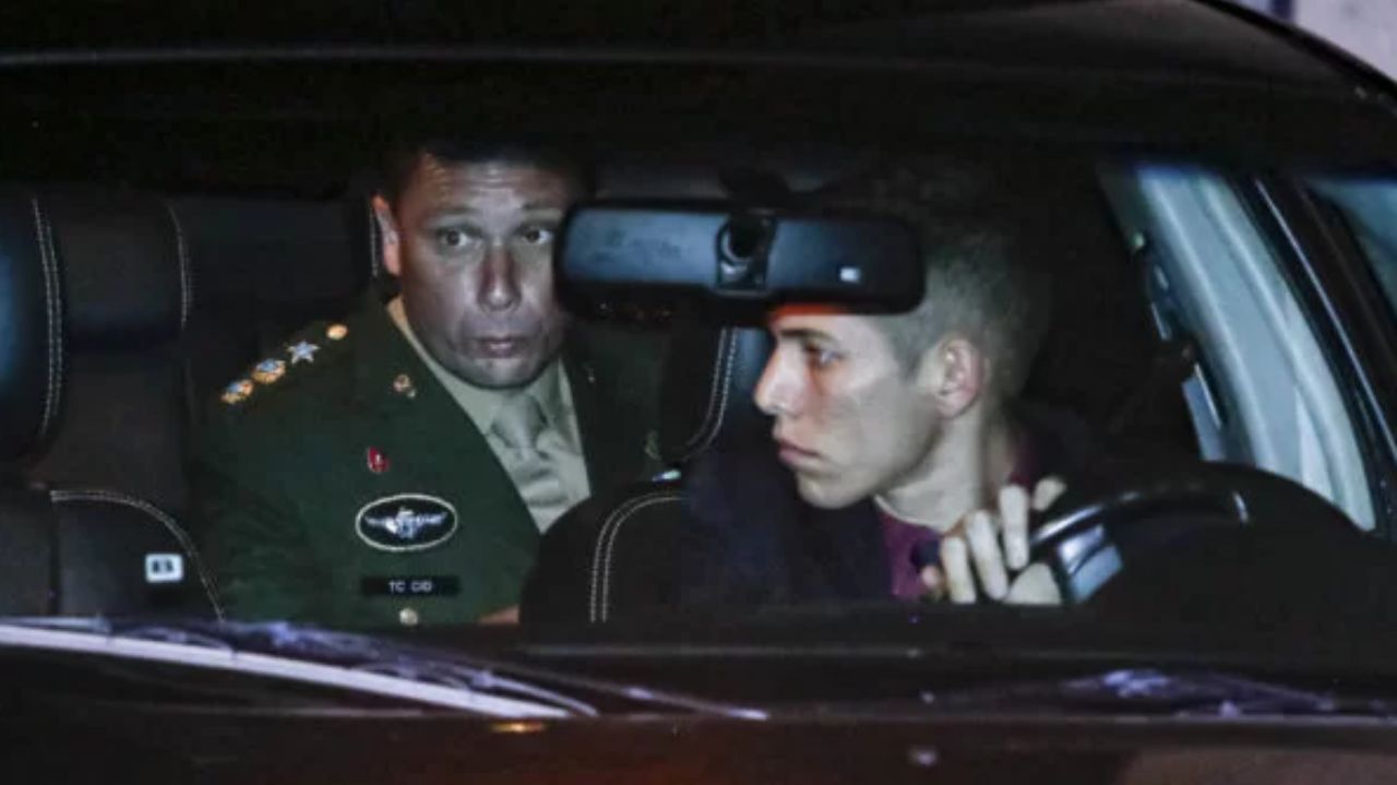 Mauro Cid dentro de carro, no banco de trás