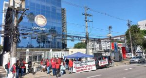 Manifestantes na porta de afiliada da Record com cartazes