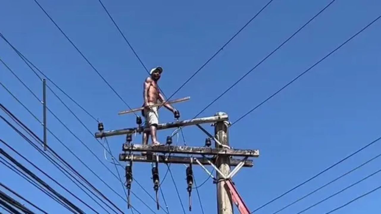Homem em cima de poste