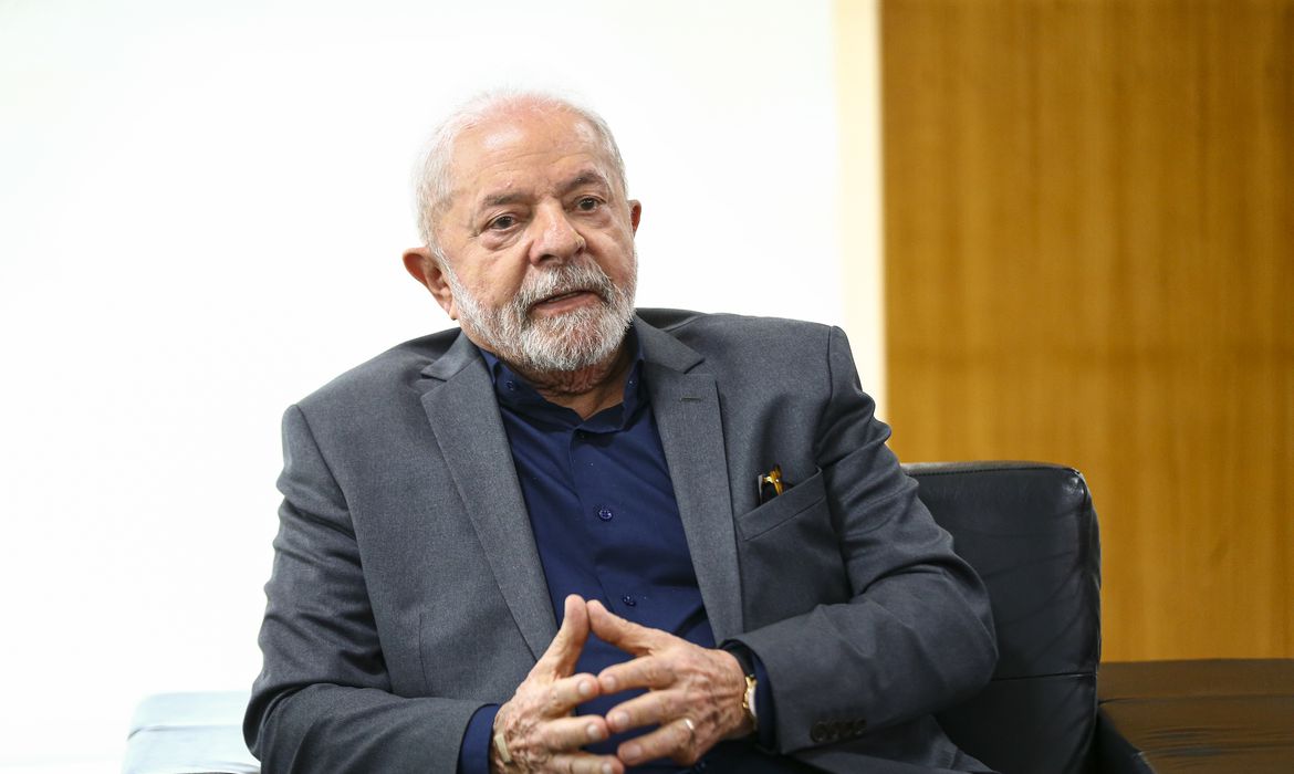 Lula sorrindo e com as mãos unidas