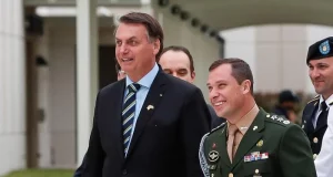 Mauro Cid e Jair Bolsonaro caminhando lado a lado e sorrindo