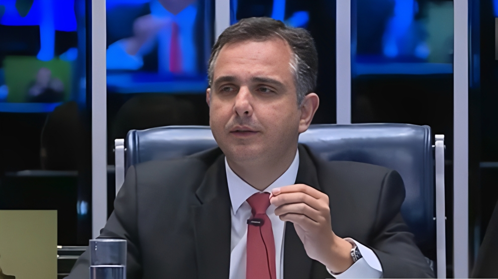 Rodrigo Pacheco de terno e gravata, falando em microfone e gesticulando