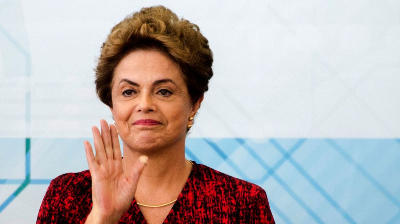 Dilma Rousseff sorrindo e acenando