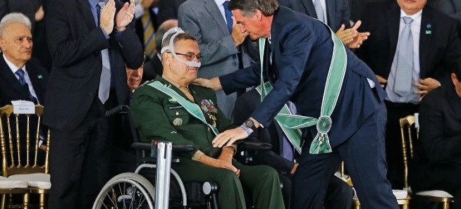 Jair Bolsonaro abaixado falando com Villas Bôas