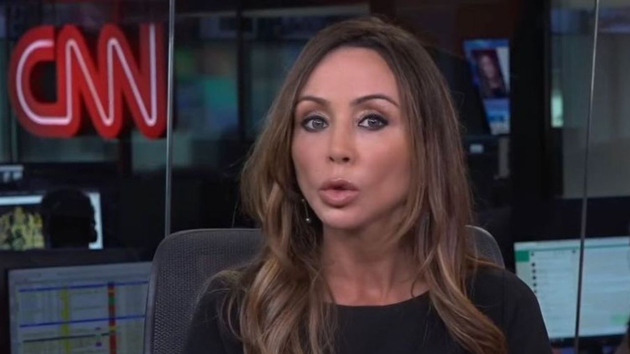 Elaine Bast de roupa escura, falando pra câmera em cenário da CNN Brasil