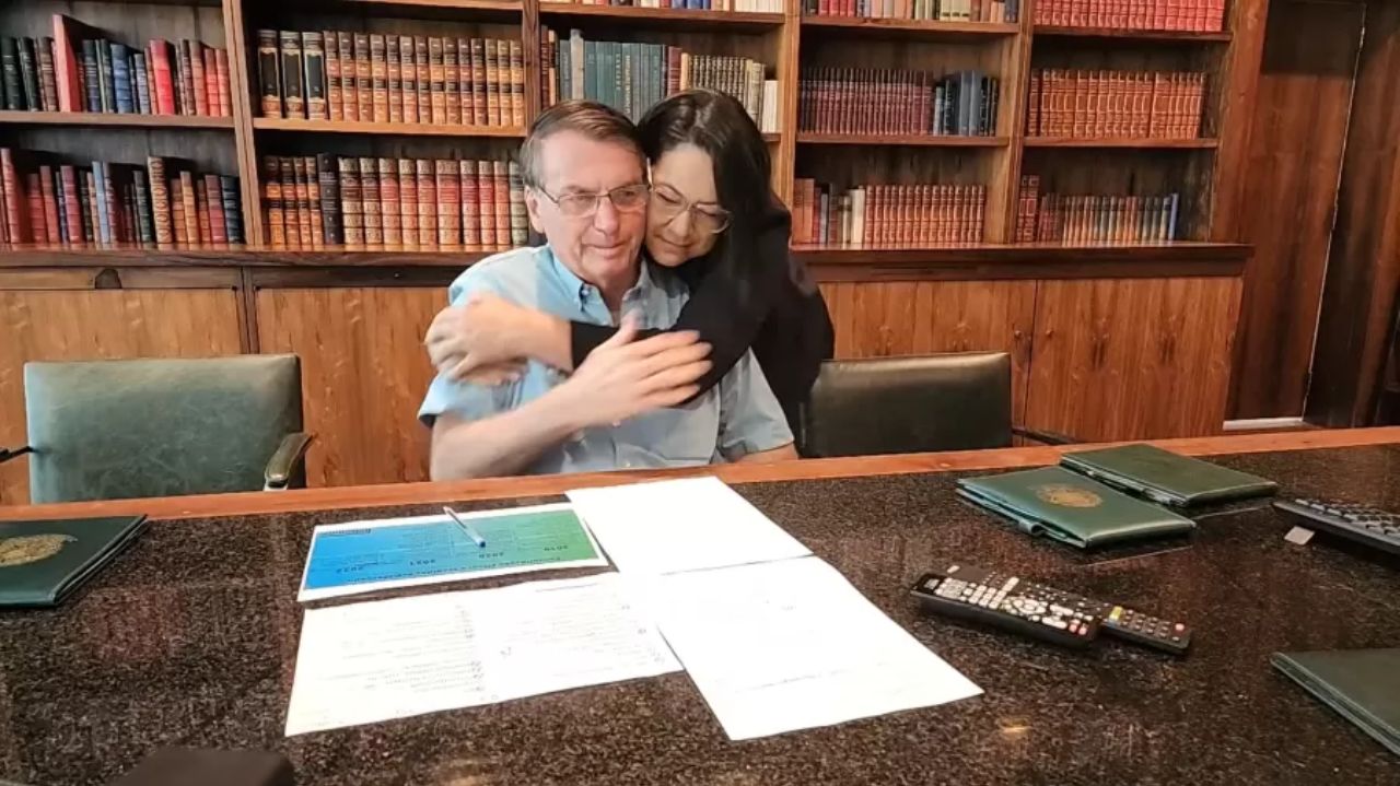 Elizangela Ramos de Souza Castelo Branco, intérprete de Libras, abraçando Jair Bolsonaro por trás