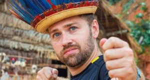 Paul Jason Staehle com cocar colorido e expressão séria