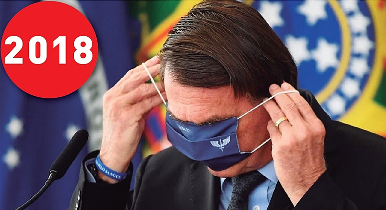 Jair Bolsonaro cobrindo o rosto com máscara azul