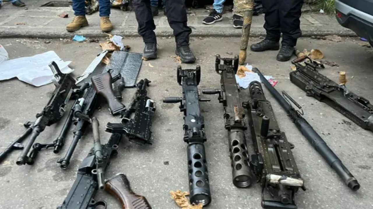 Armas no chão com pessoas atrás