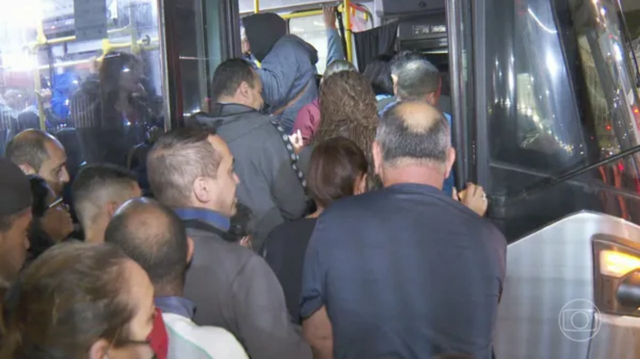 Pessoas tentando entrar em ônibus