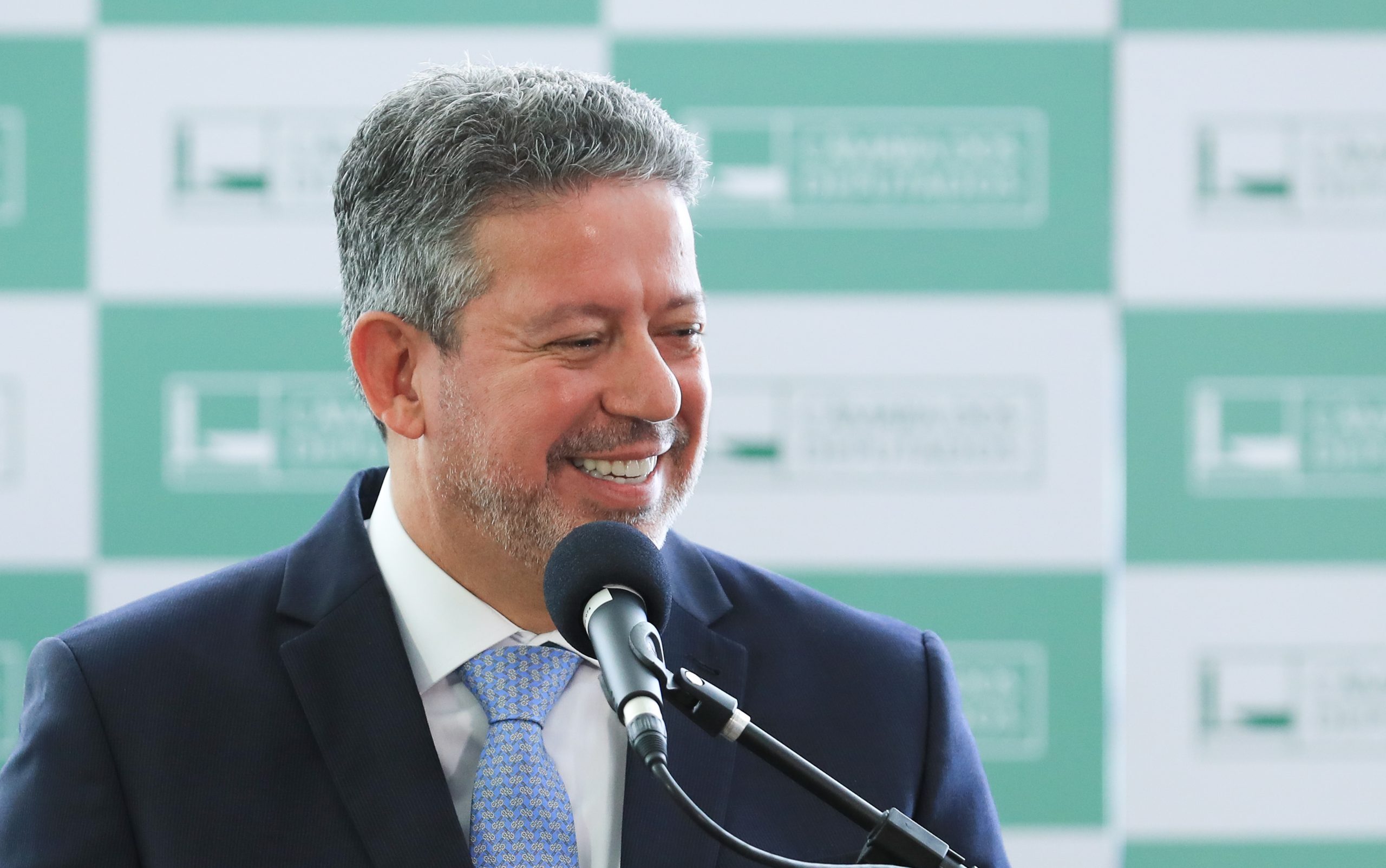 Arthur Lira olhando para o lado e sorrindo