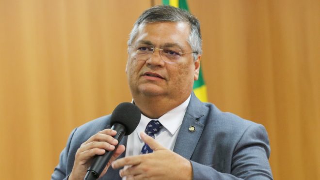 Flávio Dino de óculos, falando e gesticulando