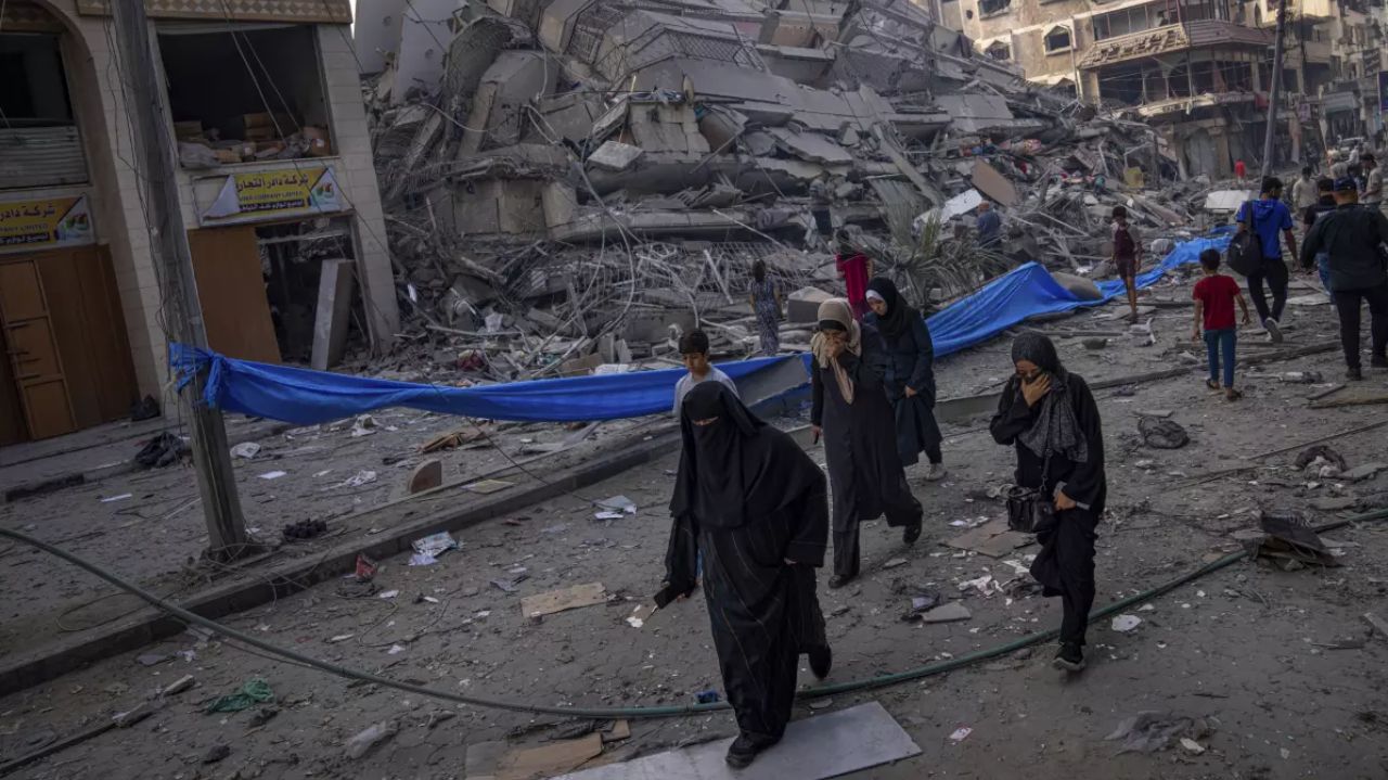 Pessoas caminhando em meio aos destroços em Gaza