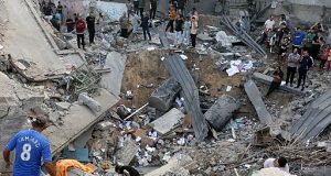 Palestinos em meio a destroços de igreja