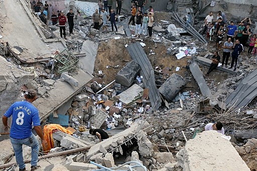 Palestinos em meio a destroços de igreja