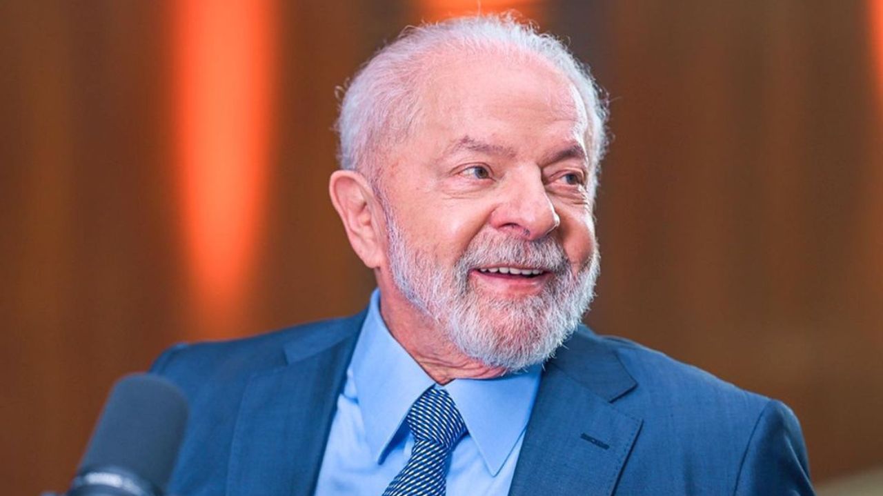 Lula olhando para o lado e sorrindo, com roupa social azul marinho