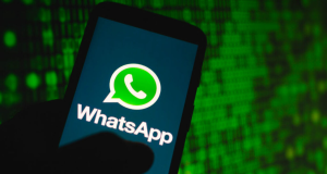 Mão segurando celular com logo de WhatsApp