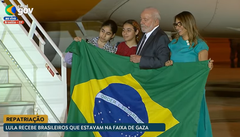 Lula e Janja recepcionando repatriados com bandeira do Brasil