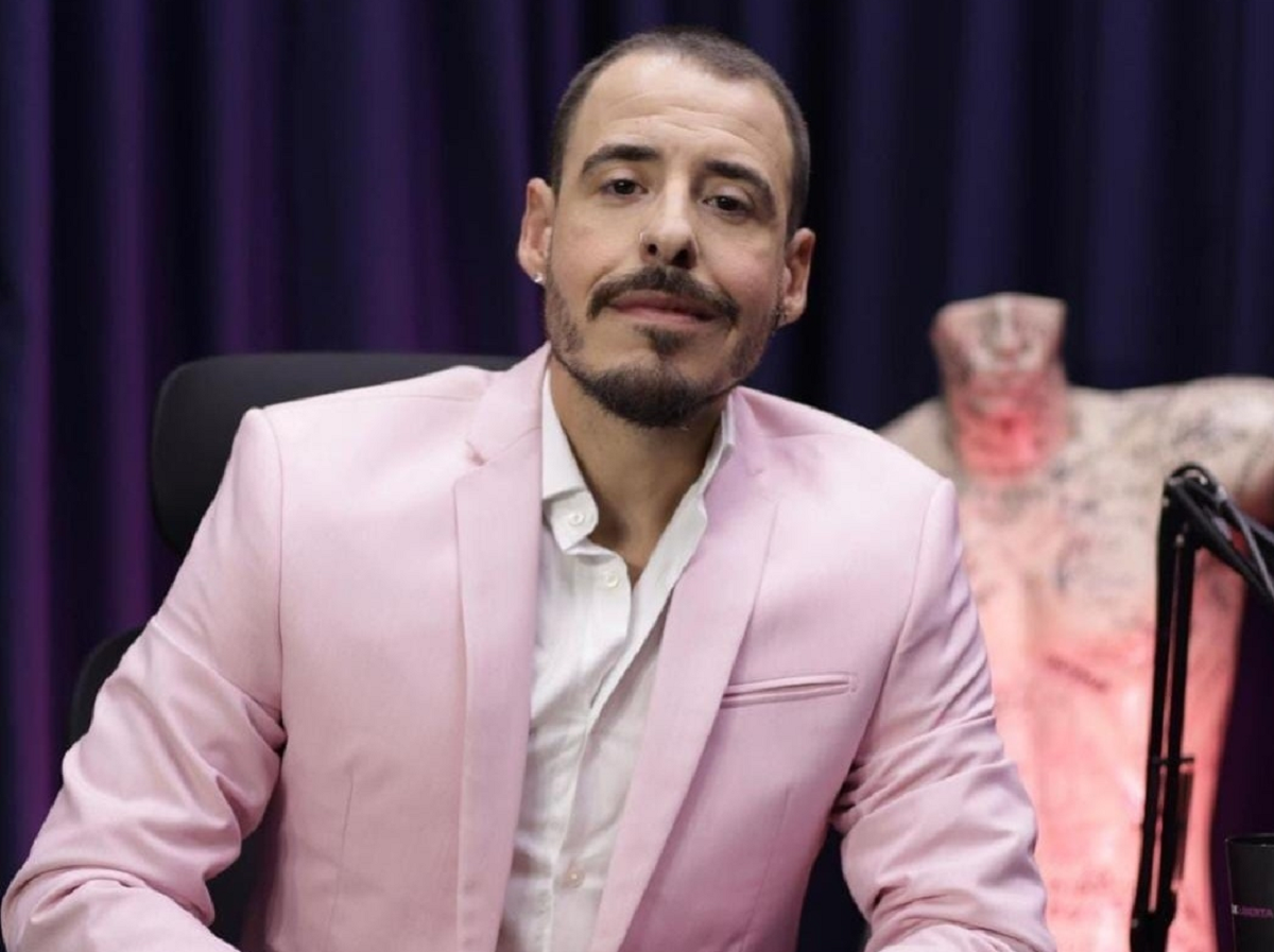 Thiago Schutz de roupa social cor de rosa e com expressão séria