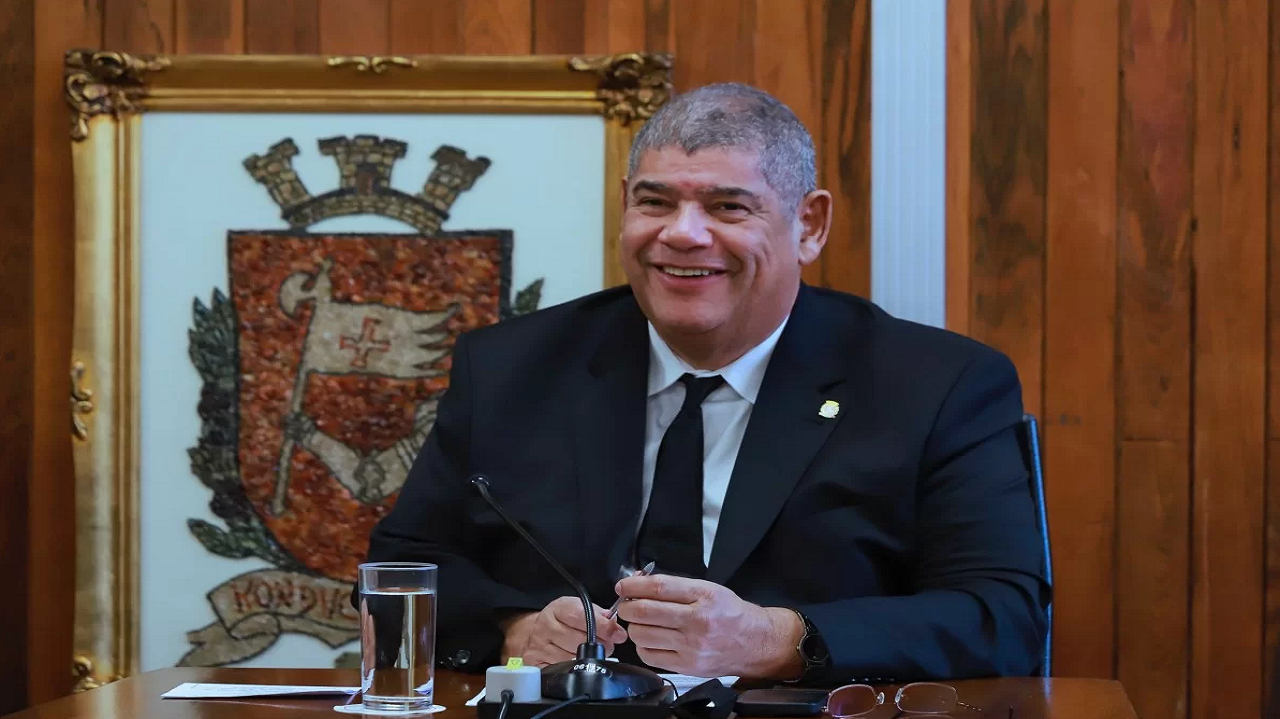 Milton Leite sentado, sorrindo