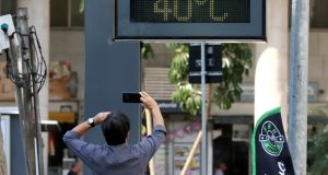 Homem fotografando relógio marcando 40 graus