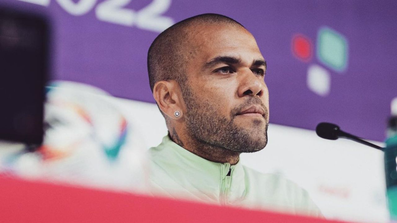 Daniel Alves em coletiva de imprensa, com expressão séria