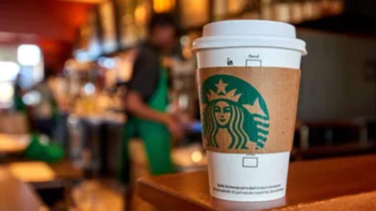Copo de café do Starbucks em primeiro plano com cafeteria de fundo