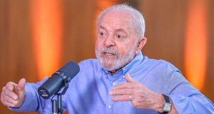 Lula de camisa social azul, falando e gesticulando
