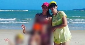 Mãe e filhas em foto na praia, crianças com imagens borradas