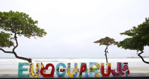 Letreiro de "eu amo Guarujá" na beira da praia