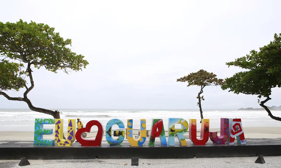 Letreiro de "eu amo Guarujá" na beira da praia