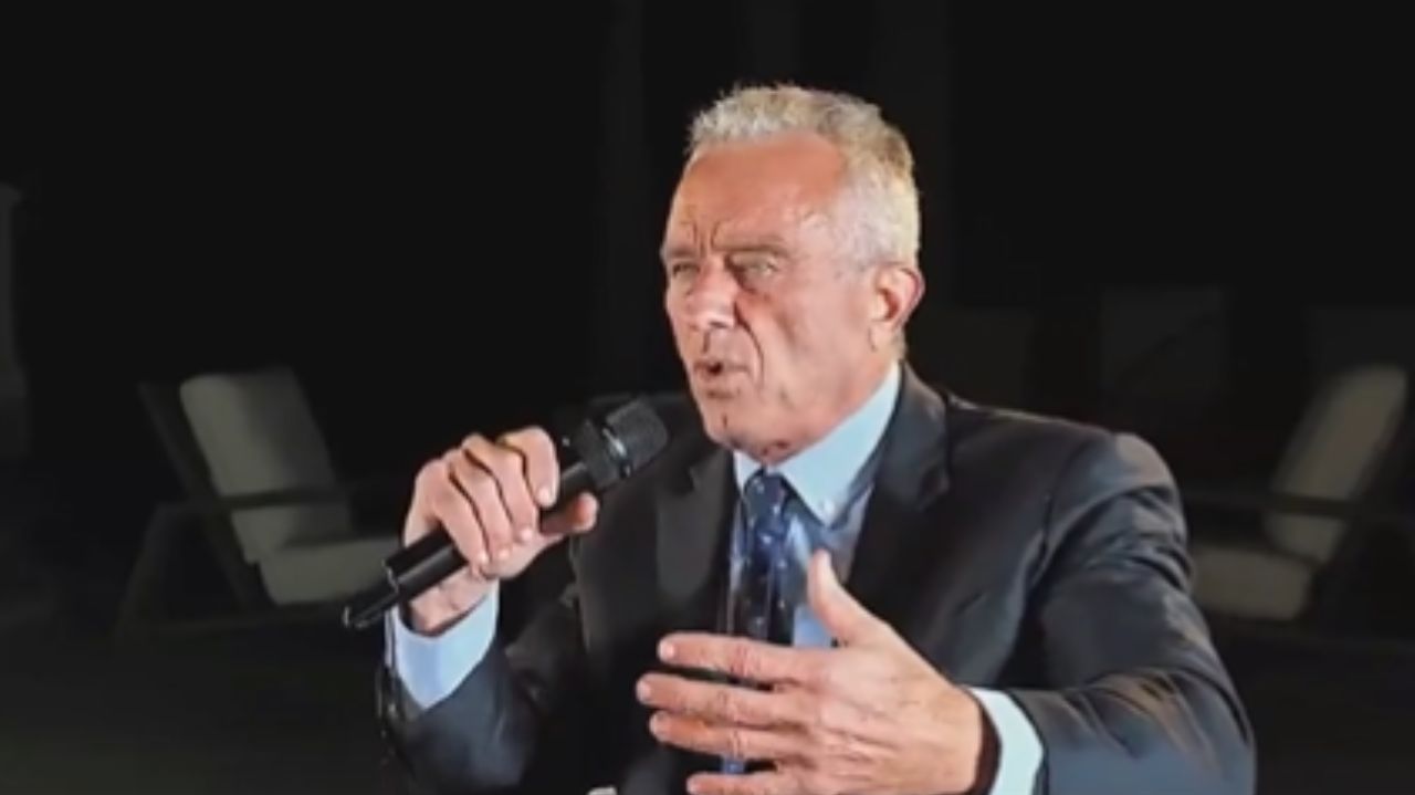 Robert F. Kennedy Jr. de roupa escura, falando e gesticulando