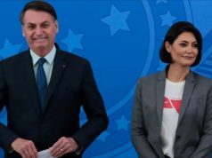 Jair e Michelle Bolsonaro sorrindo lado a lado, em pé