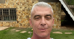 Alexandre Correa com sorriso tímido e blusa branca