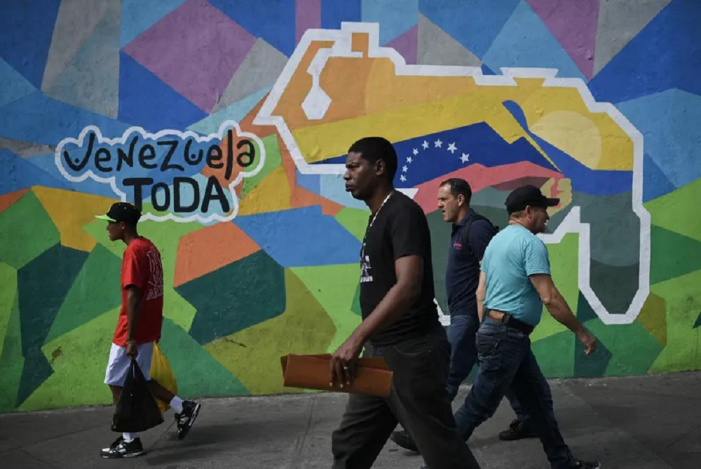 Pessoas caminhando perto de mural colorido