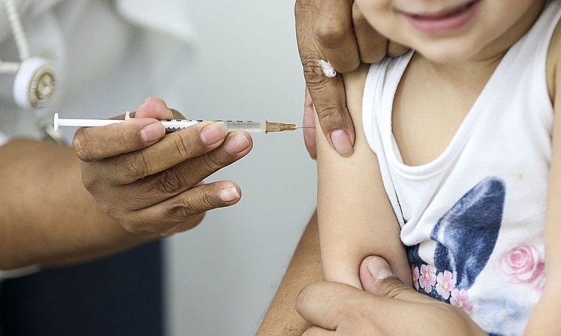 Braço de criança recebendo vacina
