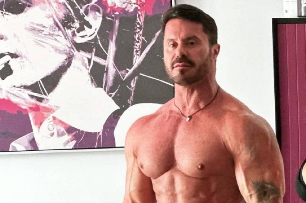 Ricardo Cariani sem camisa com expressão séria