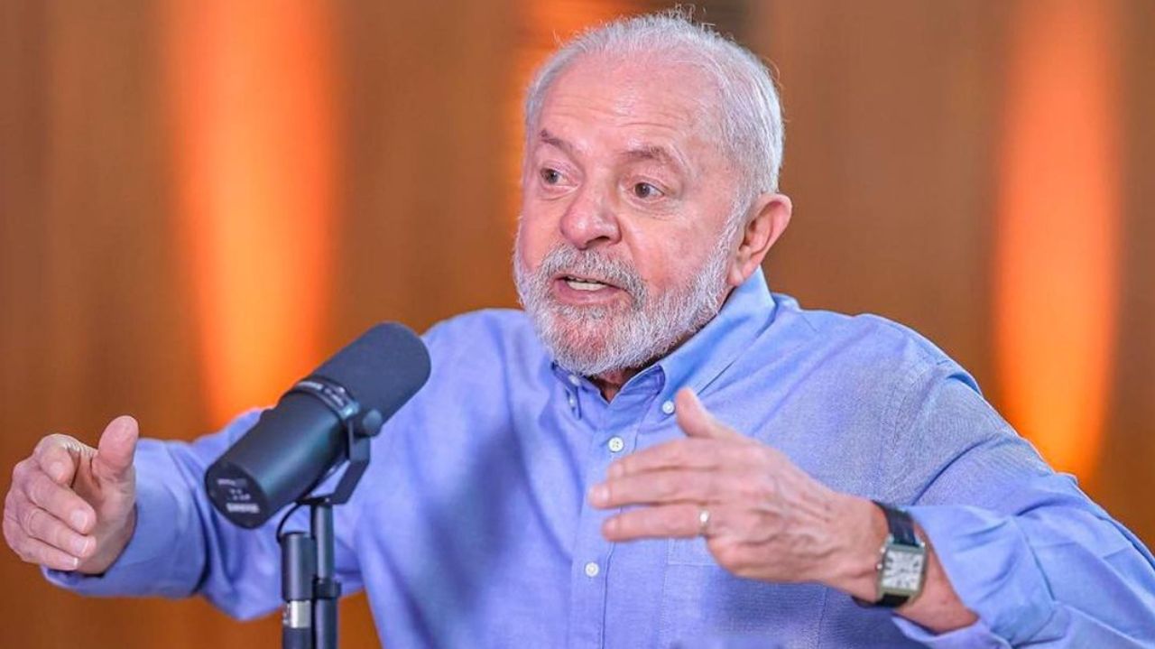 Lula falando em microfone e gesticulando, com roupa social azul e expressão séria