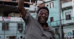Pelé sorrindo e com braço levantado em sinal de comemoração